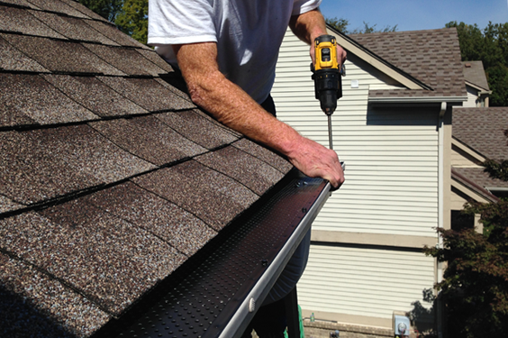 Technician securing the gutter system at the roof edge