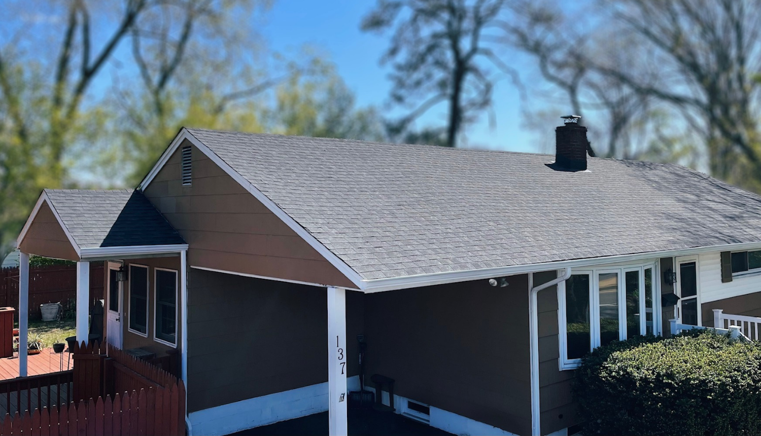 Completed gray asphalt shingle roof spanning a residential home