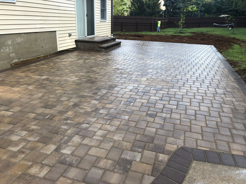 Finished interlocking paver patio beside a home