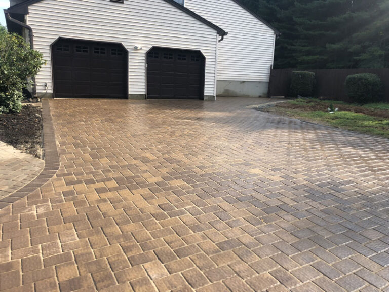 Even paver surface with a curved border outside a garage