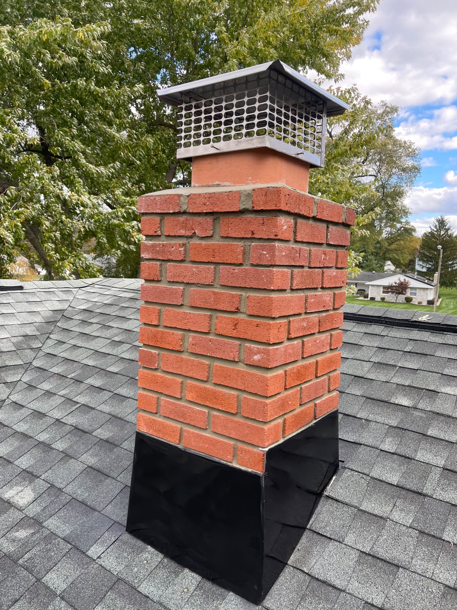 Brick chimney with roof flashing and a protective cap from Golden Master's project gallery