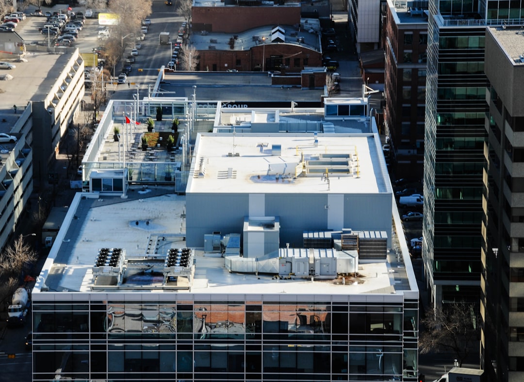 White flat commercial roof with drainage and rooftop penetrations